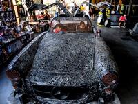 This photograph taken on July 18, 2020 shows children playing in a car made of scrap metal parts at the Ban Hun Lek museum in Ang Thong, some 100km north of Bangkok. "Ban Hun Lek" or "The House of Steel Robots" is a museum where a collective of artists display their scrap metal creations depicting popular comics and sci-fi film characters. Mladen ANTONOV / AFP