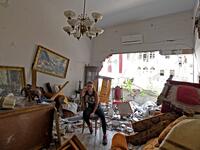 A woman sits amidst the rubble in her damaged house in the Lebanese capital Beirut on August 6, 2020, two days after a massive explosion shook the Lebanese capital. The blast, which appeared to have been caused by a fire igniting 2,750 tonnes of ammonium nitrate left unsecured in a warehouse, was felt as far away as Cyprus, some 150 miles (240 kilometres) to the northwest. The scale of the destruction was such that the Lebanese capital resembled the scene of an earthquake, with thousands of people left home