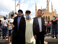 A man poses for a picture with a cardboard cut-out of Hassan Nasrallah (L), the head of Lebanon's Shiite Muslim movement Hezbollah, and former Foreign Minister Gibran Bassil hung by Lebanese protesters in downtown Beirut on August 8, 2020, during a demonstration against a political leadership they blame for a monster explosion that killed more than 150 people and disfigured the capital Beirut. AFP