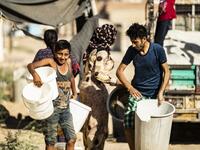 Residents carry plastic buckets to fill up water from cisterns, provided by humanitarian organisations, during a water outage in Syria's northeastern city of Hasakah on August 22, 2020. As coronavirus spreads across northeast Syria, residents in Hasakeh have been caught up in the latest spat between Turkish forces to the north and Syrian Kurds it views as "terrorists". In October last year, Turkish forces occupied a 120-stretch (70-mile) stretch of land inside the Syrian border, including the Alouk power st