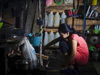 This picture taken on July 24, 2020 shows Tati (not her real name), who got married under age in March 2020, cooking in her kitchen in North Botteng in Mamuju, West Sulawesi. Child marriage has long been common in traditional communities from the Indonesian archipelago to India, Pakistan and Vietnam, but numbers had been decreasing as charities made inroads by encouraging access to education and women's health services. YUSUF WAHIL / AFP