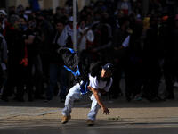 A protestor throws a stone towards riot police during the fifth straight day of protests against police brutality in Bogota on September 13, 2020. DANIEL MUNOZ / AFP