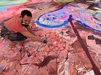 Contemporary British artist Sacha Jafri works on his record-breaking painting entitled 'The Journey of Humanity' on September 23, 2020, in the Emirati city of Dubai. The painting, which measures the size of two football fields, can be seen at a hotel in Dubai, where Jafri spent months of lockdown due to the coronavirus pandemic. The gigantic artwork is part of his project 'Humanity Inspired' and with it he hopes to raise 30 million USD to fund health and education initiatives for children living in poverty 