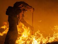 Los Angeles County firefighters, using only hand tools, keep fire from jumping a fire break at the Bobcat Fire in the Angeles National Forest on September 11, 2020 north of Monrovia, California. California wildfires that have already incinerated a record 2.3 million acres this year and are expected to continue till December. The Bobcat Fire has grown to more than 26,000 acres. David McNew/Getty Images/AFP DAVID MCNEW / GETTY IMAGES NORTH AMERICA / Getty Images via AFP