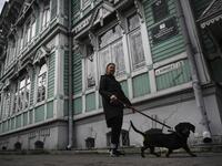 A woman walks a dog past former house of Russian architect Stanislav Khomich, 1904, a traditional wooden house in the Siberian city of Tomsk, on September 8, 2020. Tomsk is considered to be one of the oldest towns in Siberia founded in 1604. Wooden architecture is one of the symbols of the city of Tomsk, its distinctive feature. Today Tomsk is the only city in Siberia where the background wooden buildings have been preserved, reflecting the manor structure of the city streets. Unfortunately, many wooden hou