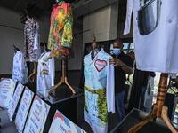 A gallery worker organizes white coats used by doctors fighting against COVID-19 and decorated by Panamanian artists, in Panama City, on September 26, 2020. More than 20 doctor's coats fighting against COVID-19 that were disinfected and painted by Panamanian artists will be auctioned off from October 1 to 4. The funds will go to 20 health centers. Luis ACOSTA / AFP