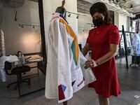 Dr. Fulvia Vergara holds her white coat decorated by Panamanian artist Genaro Rodriguez in Panama City, on September 26, 2020. More than 20 doctor's coats fighting against COVID-19 that were disinfected and painted by Panamanian artists will be auctioned off from October 1 to 4. The funds will go to 20 health centers. Luis ACOSTA / AFP