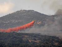 A firefighting plane tries to extinguish a forest fire near the Israeli military base of Har Dov on Jabal al-Shaykh, a strategic and fortified outpost at the crossroads between Israel, Lebanon, and Syria, on October 10, 2020. JALAA MAREY / AFP