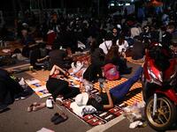Pro-democracy protesters rest on the ground during an anti-government rally next to Government House in Bangkok on October 14, 2020. Jack TAYLOR / AFP