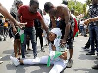 A Nigerian woman based in South Africa weep as others comfort her during a protest outside their embassy in Pretoria on October 21, 2020 in solidarity with Nigerian youth who are demanding an end to police brutality in the form of The Nigerian Police Force Unit, Special Anti-Robbery Squad (SARS). Phill Magakoe / AFP
