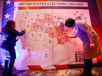 People colour in an electoral map during a US presidential election watch party at the US embassy in Ulaanbaatar, the capital of Mongolia on November 4, 2020. Byambasuren BYAMBA-OCHIR / AFP