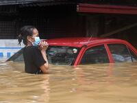 A resident makes her way through a flooded street to shelter after Typhoon Vamco hit, in Marikina City, suburban Manila on November 12, 2020. Ted ALJIBE / AFP