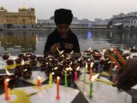 A Sikh boy lights oil lamps on the occasion of Bandi Chhor Divas, a Sikh festival coinciding with Diwali, the Hindu festival of Light, at the Golden Temple in Amritsar on November 14, 2020. NARINDER NANU / AFP