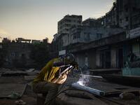 In this picture taken on November 12, 2020 a dockyard worker welds a ship's part on the banks of the Buriganga River in Char Kaliganj on the outskirts of Dhaka. Rivers are the lifeblood of the delta nation of 168 million people where much of the low-lying land is accessed via boat, with Bangladesh's strong economic growth of recent years fuelling more investments in new and bigger ships. Munir UZ ZAMAN / AFP