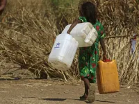 An Ethiopian refugee girl walks carrying water containers at Um Raquba camp in Sudan's eastern Gedaref province on November 28, 2020. Sudan needs $150 million in aid to cope with the flood of Ethiopian refugees crossing its border from conflict-stricken Tigray, the UN refugee agency chief said during a visit to a camp. ASHRAF SHAZLY / AFP