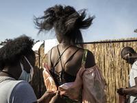 A fashion model gets a dress fitted ahead of the start of Dakar Fashion Week in Dakar on December 12, 2020. JOHN WESSELS / AFP