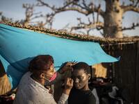 A fashion model get her make-up and hair done ahead of the start of Dakar Fashion Week in Dakar on December 12, 2020. JOHN WESSELS / AFP