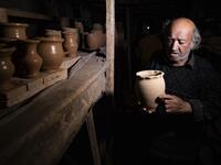 Syrian-Armenian potter Misak Antranik Petros arranges pottery vases at his workshop located inside an ancient mud-brick house near the city of Qamishli in Syria's northeastern Hasakeh province, on December 19, 2020. Petros was only a teenager when he had to take over for his sick father and become the main potter of the family. He has since become a master of the craft, and is keen to pass his skills on.  Delil SOULEIMAN / AFP