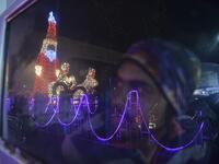 A car driver looks at a model of Santa Claus illuminated, on the eve of Christmas in Siliguri on December 24, 2020. DIPTENDU DUTTA / AFP