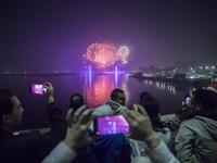 People watch fireworks explode over the River Nile in the Egyptian capital Cairo during New Year's Eve celebrations on December 31, 2020. Khaled DESOUKI / AFP