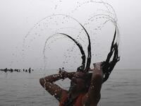 A Sadhu or a Hindu holyman takes a dip at the confluence of Ganges and the Bay of Bengal during the Gangasagar Mela on the occasion of Makar Sankranti, a day considered to be of great religious significance in Hindu mythology, at Sagar Island, around 150 kms south of Kolkata on January 14, 2021. Dibyangshu SARKAR / AFP
