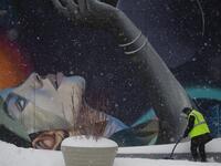 A worker cleans the stairs outside The Vessel in Hudson Yards during a winter storm on February 1, 2021 in New York City. A powerful winter storm is set to dump feet of snow along a stretch of the US east coast including New York City on February 1, 2021, after blanketing the nation's capital. The National Weather Service issued storm warnings from Virginia to Maine -- a swathe home to tens of millions of people -- and forecast snowfall of 18 to 24 inches (45-60 centimeters) in southern New York, northeaste