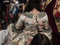 An employee (Front R) helps a reveller put on a traditional carnival costume in 'La Bauta' shop in Venice on February 6, 2021, as the traditional Venice carnival is being cancelled due to the Covid-19 pandemic. Marco Bertorello / AFP