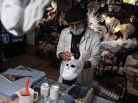 Mask artisan Hamid Seddighi works on a papier-mache mask in his laboratory 'Ca del Sol' in Venice on February 6, 2021, as the traditional Venice carnival is being cancelled due to the Covid-19 pandemic. Marco Bertorello / AFP