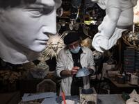 Mask artisan Hamid Seddighi works on a papier-mache mask in his laboratory 'Ca del Sol' in Venice on February 6, 2021, as the traditional Venice carnival is being cancelled due to the Covid-19 pandemic. Marco Bertorello / AFP
