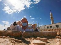 A worker employed by a pilot project run by the UN cultural agency UNESCO, restores a stone wall at an ancient church complex, in the small town of Rihab, some 70 kilometres north of the Jordanian capital Amman, on February 9, 2021. In the ruins of the ancient Byzantine church in Jordan, local townspeople and Syrian refugees work side by side on a project that unites preserving cultural heritage and fighting poverty.  Khalil MAZRAAWI / afp