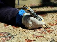A worker employed by a pilot project run by the UN cultural agency UNESCO, restores a mosaic floor at an ancient church complex, in the small town of Rihab, some 70 kilometres north of the Jordanian capital Amman, on February 9, 2021. In the ruins of the ancient Byzantine church in Jordan, local townspeople and Syrian refugees work side by side on a project that unites preserving cultural heritage and fighting poverty.  Khalil MAZRAAWI / afp
