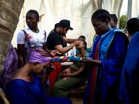 Gold miners are helped to get ready in the backstage prior to take part in a fashion show as part of the first edition of the International Gold Fair Afrik'Or, in Bamako, on February 12, 2021. The Princess of Burundi Esther Kamatari, selected 34 women among gold mines workers in southern Mali, to walk down the catwalk for a fashion show organised during the International Gold Fair. Gold represents 15% of Mali's exports and more than 20% of its GDP estimated at nearly US$20 billion by the end of 2019. MICHEL