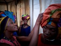 Gold miners are helped to get ready in the backstage prior to take part in a fashion show as part of the first edition of the International Gold Fair Afrik'Or, in Bamako, on February 12, 2021. The Princess of Burundi Esther Kamatari, selected 34 women among gold mines workers in southern Mali, to walk down the catwalk for a fashion show organised during the International Gold Fair. Gold represents 15% of Mali's exports and more than 20% of its GDP estimated at nearly US$20 billion by the end of 2019. MICHEL