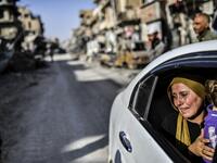 woman cries as she looks at her house in Raqa
