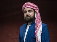 A Syrian Kurdish man in traditional attire poses for a picture during the yearly ceremony celebrating "Kurdish Clothing Day"