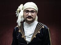 A Syrian Kurdish man in traditional attire poses for a picture 