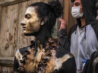 A carnival participant dressed in costume and wearing body paint 