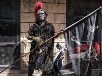 A carnival participant dressed in costume poses for a picture 