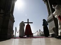Archbishop of Paris Michel Aupetit carries the holy cross at the Way of the Cross ceremony during the Good Friday as part of the Holy Week 