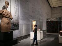 A visitor looks at a large statue of the 18th dynasty Pharaoh Akhenaten at Egypt's new National Museum of Egyptian Civilisation (NMEC)