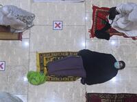 A woman rests prior to night prayers on the first day of Ramadan at the Istiqlal grand mosque in Jakarta