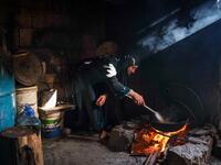 A woman fries potatoes as she prepares the fast-breaking "Iftar" meal