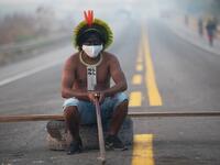  In this file photo taken on August 18, 2020 a member of the Kayapo tribe sits after they blocked highway BR163 during a protest on the outskirts of Novo Progresso in Para State, Brazil