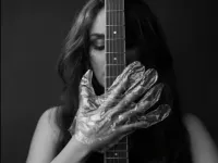 The musician in foil gloves is holding the instrument