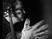 A musician in foil gloves is playing an instrument