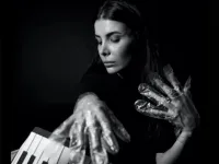 A musician in foil gloves is playing an instrument