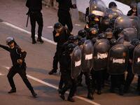 A Moroccan riot police throws a rock back at migrants during light clashes in the northern town of Fnideq, close to the border between Morocco and Spain's North African enclave of Ceuta on May 19, 2021. Migrants were still trying to cross from Morocco into the Spanish enclave of Ceuta on May 19, 2021, after a record 8,000 people poured over the border this week, escalating tensions between Rabat and Madrid. Some 5,600 migrants had already been sent back