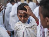 An Ethiopian Orthodox child gets a cross drawn in his forehead with ashes during the religious celebration of Saint Michael in the city of Bahir Dar, Ethiopia