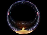This picture taken with a fish-eye lens shows the Olympic cauldron and flame during the opening ceremony of the Tokyo 2020 Olympic Games, at the Olympic Stadium, in Tokyo