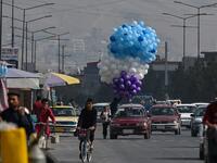 An Afghan man selling balloons rides in a car in Kabul on September 21, 2021. 